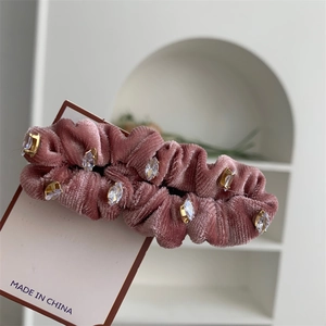 Détail de la pince à cheveux en velours rose avec cristaux sur support doré