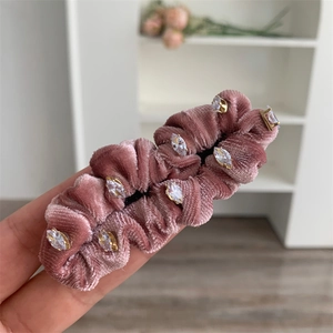 Détail d'une pince à cheveux en velours avec strass marquise et texture plissée