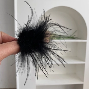 Gros plan de plumes noires naturelles sur une pince à cheveux élégante pour femme