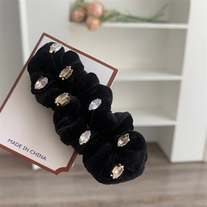 Gros plan sur chouchou en velours noir avec strass marquise et montures dorées