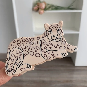 Detail of leopard shaped acetate hair claw clip with black spots in hand display