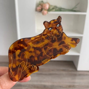 Detailed view of leopard-shaped acetate hair claw clip with amber tortoise shell texture