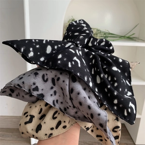 Vintage polka dot and leopard print square hair scrunchies held in hand for women