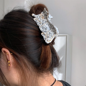 Minimalist acetate leopard hair claw clip with golden edges on woman's hair