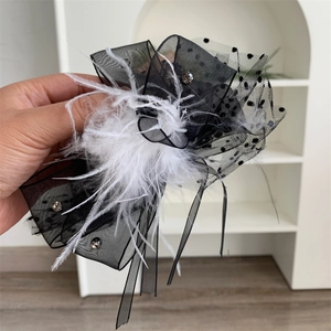 Detail of plush hair claw clip featuring lace polka dots and a rhinestone bow