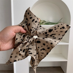 Detailed view of the leopard print polka dot bow scrunchie with soft fabric texture