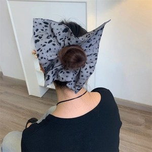 Close-up of a large polka dot bow hair scrunchie styled on a bun with soft fabric
