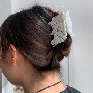 Détail d'une pince à cheveux en acétate léopard sur les cheveux d'un mannequin