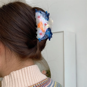 Pearlescent large hair claw clip with ocean dolphin and flower patterns in hair