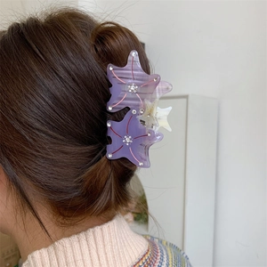 Detail view of a purple acetate starfish hair claw clip with sparkling rhinestones on hair