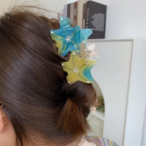 Detail of starfish hair claw with crystals shown in a semi-tied hairstyle