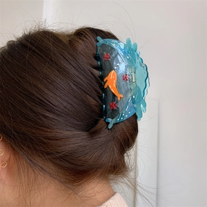 Detailed view of the ocean series blue wave hair claw clip styled on dark brown hair
