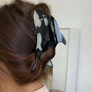 Orca shaped black and white acetate hair claw clip worn on long brown hair
