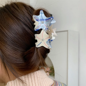 Close-up of starfish acetic acid hair clips with crystals on long brown hair