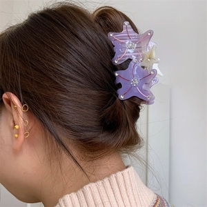 Detail of starfish hair claw clip with rhinestones worn on hair from a side back view