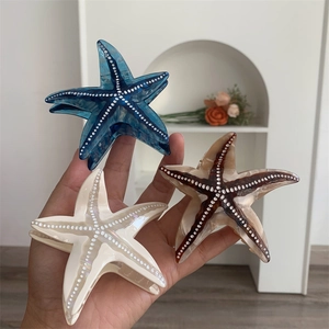 Gros plan détaillé des pinces à cheveux étoile de mer en acétate avec motifs marbrés