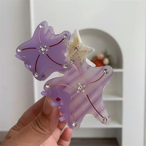 Detail of starfish hair claws in purple and cream acetate with sparkling rhinestones