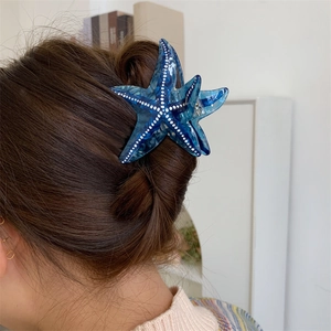 Détail de la pince à cheveux étoile de mer bleu marine à pois blancs sur cheveux