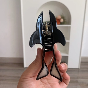 Detail showing high-quality black and white shark hair claw clip with golden metal spring