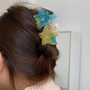 Starfish gradient hair claw clip with rhinestones worn on back of woman's head