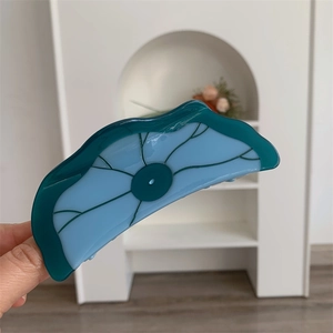Détail de la pince à cheveux en résine bleue et verte en forme de feuille de lotus