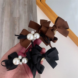 Close-up of elegant double layered bow hair clips with white pearls and metal tag