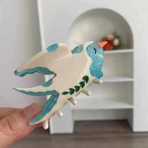 Détail de la pince à cheveux hirondelle en acétate avec marbrures bleues et crème