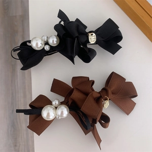 Detail of fabric bow hair clips with white pearls and gold Made With Love tags