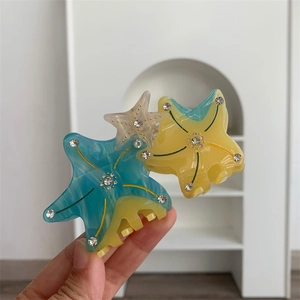Close-up of starfish acetate hair claw clip with rhinestones in blue and yellow
