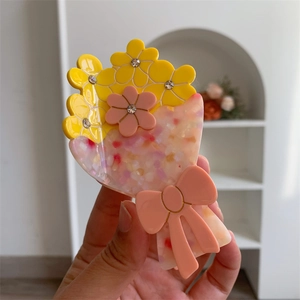 Dettaglio della pinza per capelli in acetato con fiori colorati e strass scintillanti