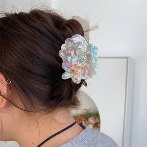 Iridescent shell hair claw with pearls and starfish detail worn on hair