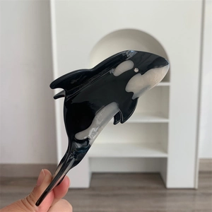 Detailed view of an orca shaped hair claw clip with black and white acetate finish