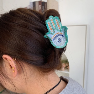 Pince à cheveux Main de Fatma avec motif Œil Bleu vue détaillée sur cheveux bruns
