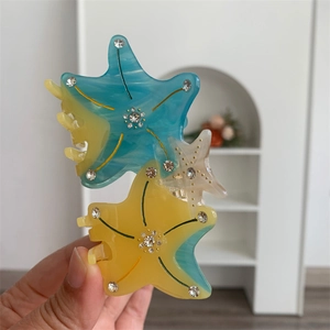 Detailed close-up of a starfish hair claw clip with acetate finish and sparkly rhinestones