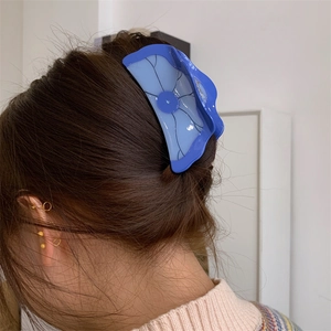 Vue détaillée de la grande pince à cheveux bleue en acétate en forme de lotus