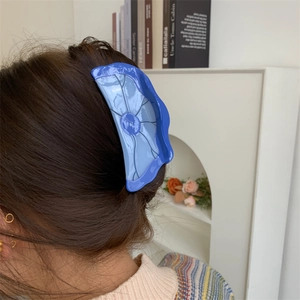 Pince à cheveux en acétate bleue avec design feuille de lotus sur un mannequin