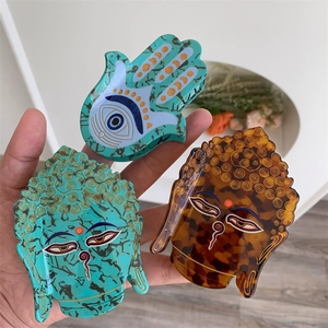 Détails des pinces à cheveux main de hamsa et tête de bouddha en acétate de luxe