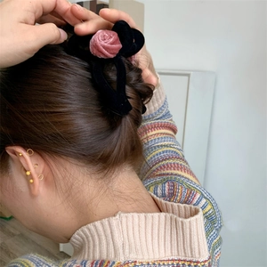 Detail view of pink velvet rose hair claw clip worn on a ponytail for elegant hair styling