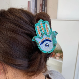 Détail de la pince à cheveux Hamsa en acétate marbré avec motif Evil Eye bleu