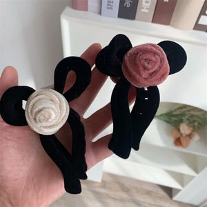 Close-up of velvet bow hair claws with cream and pink fabric rose details