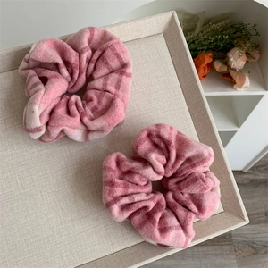 Lot de deux chouchous à carreaux roses doux sur un plateau pour des coiffures douces