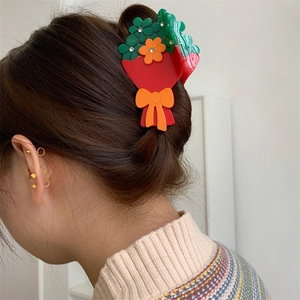 Dettaglio del fermaglio per capelli in acetato a fiori con strass sui capelli della modella
