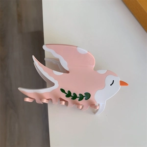 Détail de la pince à cheveux en acétate en forme d'oiseau avec motif de feuille