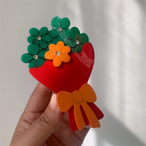 Dettaglio del fermaglio per capelli a fiori in acetato con strass rossi, verdi e arancio