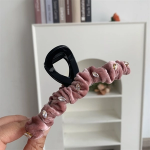 Détail de la pince à cheveux en velours avec strass et nœud élégant pour femme