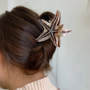 Pince à cheveux étoile de mer en acétate avec motif écaille de tortue portée par un modèle