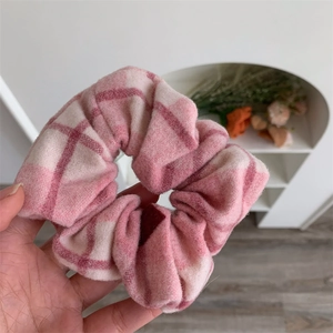 Détail d'un chouchou à carreaux rose et blanc en tissu doux au design froissé