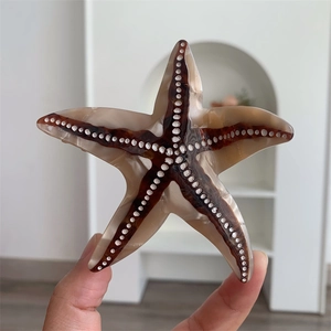 Détail macro de la pince à cheveux étoile de mer avec motif écaille et pois blancs
