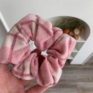 Gros plan d'un chouchou à carreaux roses montrant la texture douce du tissu et le motif rétro