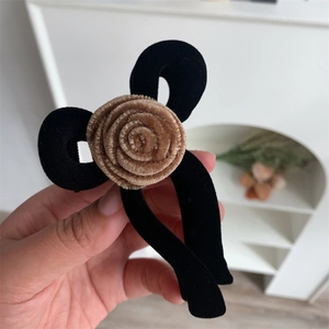 Detail view of large velvet flower hair claw clip with khaki spiral rose texture